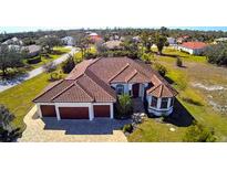 Aerial view of a large house with a three-car garage and a spacious lot at 2 Windward Rd, Placida, FL 33946