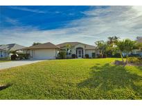 Single-story home with a well-manicured lawn and attached garage at 8 Sportsman Rd, Rotonda West, FL 33947