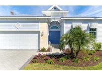 House exterior showcasing a light blue facade and a double blue door at 8768 Conch Ave, Placida, FL 33946