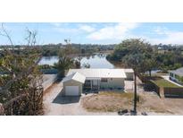 Charming single-story home with a metal roof, a one-car garage, and a waterfront view at 1493 New Point Comfort Rd, Englewood, FL 34223