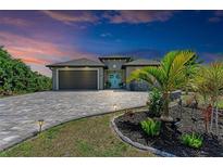 One-story home with teal door, paver driveway, and landscaped yard at 237 Albatross Rd, Rotonda West, FL 33947