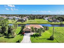 Aerial view of single-Gathering home with water access, lush landscaping, and neighborhood in background at 39 Tournament Rd, Rotonda West, FL 33947