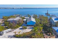 Aerial view of waterfront home with boat docks and surrounding houses at 8888 Bay St, Placida, FL 33946