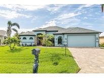 Charming light blue home boasts a manicured green lawn and a decorative mermaid mailbox, radiating curb appeal at 9548 Applin Cir, Port Charlotte, FL 33981