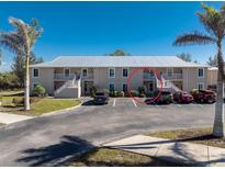 Ground-level condo building with parking and tropical landscaping at 9900 Fiddlers Green Cir # 137, Rotonda West, FL 33947