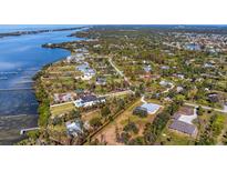 Aerial view of waterfront property with lush landscaping and multiple houses at 1080 Bayshore Dr, Englewood, FL 34223