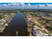 Stunning aerial view of waterfront home with a pool and private dock, showcasing canal access and neighborhood at 15524 Ruston Cir, Port Charlotte, FL 33981