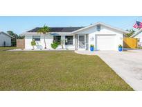 Charming single-story home with well-maintained lawn, solar panels, and inviting curb appeal at 1586 Overbrook Rd, Englewood, FL 34223