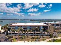 Beautiful waterfront condominium with balconies and palm trees in front of the building at 1651 Beach Rd # 301, Englewood, FL 34223