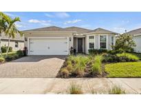 Charming single-story home featuring a two-car garage, paver driveway, and lush landscaping at 17728 Silverspur Dr, Punta Gorda, FL 33982