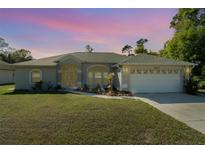 Charming single-story home featuring a well-maintained lawn and inviting curb appeal at twilight at 2657 Tusket Ave, North Port, FL 34286