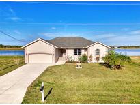 Charming single-Gathering home featuring a well-manicured lawn, garden, and attached garage by the water at 43 Blue Hen Dr, Placida, FL 33946