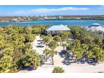 Aerial view of waterfront home with lush landscaping and private driveway at 5 Pointe Way, Placida, FL 33946