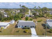 An aerial view of a charming single-story home with a well-maintained lawn and a driveway at 5280 Grobe St, North Port, FL 34287