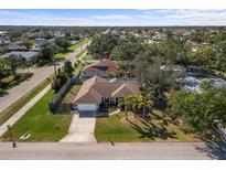 Aerial view of a fenced in single-Gathering home with mature trees and landscaping in a quiet neighborhood at 803 Diane Cir, Englewood, FL 34223