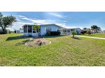 Charming single-story home with a screened in porch and well-maintained landscaping with green grass and blue skies at 8431 Nighthawk Dr, Englewood, FL 34224