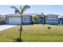 Charming single-story home featuring a lush lawn, a two-car garage, and attractive architectural details at 15610 Seafoam Cir, Port Charlotte, FL 33981