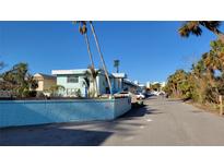 Light blue two story property with palm trees on a sunny day at 5055 N Beach Rd # 203, Englewood, FL 34223