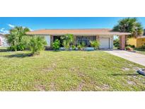 Charming single-story home with mature landscaping and covered parking on a sunny day at 6522 Coliseum Blvd, Port Charlotte, FL 33981