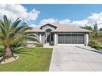 Charming single-story home featuring a well-manicured lawn and an attached two-car garage at 118 Albatross Rd, Rotonda West, FL 33947