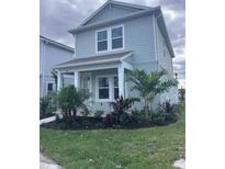 Two-story house with light blue siding, landscaping, and a front porch at 184 Eagleston Ln, Lakewood Rch, FL 34240