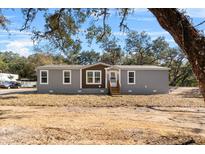 Beautiful single Gathering home with gray siding, brown trim, and green trees at 2044 Culbreath Rd, Brooksville, FL 34601