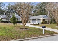 Brick ranch home with attached garage and mature landscaping at 12631 Timber Run, Dade City, FL 33525