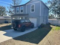 Two-story house with gray siding, a two-car driveway, and a small yard at 27096 Wakefield Dr, Brooksville, FL 34602