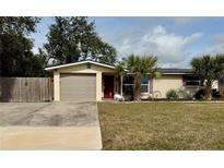 Ranch style home with a large yard, palm trees, and a two-car garage at 122 Gulf Breeze Blvd, Venice, FL 34293