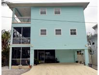 Charming light blue home featuring screened porch and balcony overlooking the scenic surroundings at 130 Bay Plz, Treasure Island, FL 33706