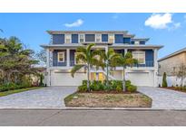 Stunning waterfront home boasts a two-story design, three-car garage, and a beautiful paver driveway at 7899 Causeway N Blvd, St Petersburg, FL 33707