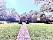 Brick house with a large front yard and walkway at 6011 Hammock Hill Ave, Lithia, FL 33547