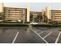 Exterior view of a condominium building with parking lot at 14900 Gulf Blvd # 113, Madeira Beach, FL 33708