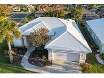 Aerial view of single-Gathering home with tile roof, two-car garage, and landscaped yard at 664 Silk Oak Dr, Venice, FL 34293