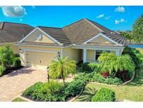 One-story home with tile roof, landscaping, and two-car garage at 11613 Marathon Cir, Venice, FL 34293