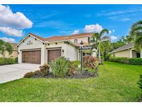 Two-story house with a three-car garage and manicured lawn at 12232 Stuart Dr, Venice, FL 34293