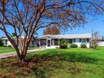 Charming single-story home featuring a well-maintained lawn and a quaint screened-in porch area at 230 E Fray St, Englewood, FL 34223