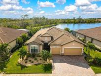 Single-Gathering home with lake view, tile roof, and landscaped yard at 13587 Vancanza Dr, Venice, FL 34293