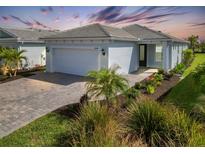 Single-story home with a white garage door and landscaping at 25544 Royal Tern Ln, Englewood, FL 34223