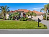 Single-story home with tile roof, lush landscaping, and a two-car garage at 804 Amaryllis Ln, Venice, FL 34292