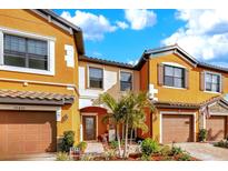 Orange townhome with two-car garage and landscaped front yard at 20428 Lagente Cir, Venice, FL 34293