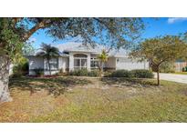 Single-story home with metal roof, landscaped yard, and driveway at 23442 Moreland Ave, Port Charlotte, FL 33954