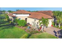 Single-story home with tile roof, landscaped yard, and two-car garage at 5584 Cantucci St, Nokomis, FL 34275