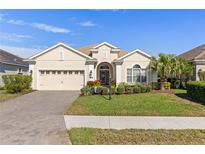 Single-story house with a two-car garage and landscaped lawn at 10788 Trophy Dr, Englewood, FL 34223