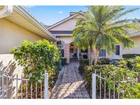 Inviting front entry with brick pavers, lush landscaping, and a charming walkway at 2232 Lynx Run, North Port, FL 34286