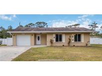 Tan house with white garage door and landscaping at 5296 Rolla Rd, Venice, FL 34293