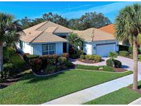 Single-story home with tile roof, landscaped yard, and two-car garage at 589 Pond Willow Ln, Venice, FL 34292