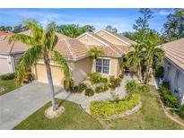 Single-story home with tile roof, landscaping, and two-car garage at 125 Amora Ave, Venice, FL 34285