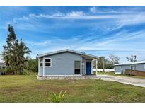 Charming single-story home featuring blue siding, a covered entryway, and well-maintained landscaping at 215 Portia N St, Nokomis, FL 34275