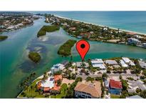 Aerial view of waterfront home with pool, dock, and lush tropical landscaping near the ocean at 922 Casey Cove Dr, Nokomis, FL 34275